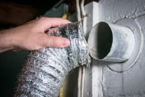 Flexible aluminum dryer vent hose, removed for cleaning/repair/maintenance.